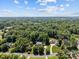 A scenic aerial view showcases the property and its lush, tree-lined surroundings under a partly cloudy sky at 1019 Westlake Dr, Kannapolis, NC 28081