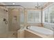 Elegant bathroom featuring a glass shower enclosure and soaking tub under a window with plantation shutters at 1019 Westlake Dr, Kannapolis, NC 28081
