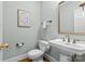 Elegant half bathroom featuring pedestal sink, decorative mirror, and neutral color palette at 1019 Westlake Dr, Kannapolis, NC 28081