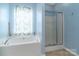 Bathroom featuring soaking tub, glass enclosed shower and natural light at 1027 Writers Way, Cornelius, NC 28031