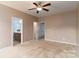Carpeted primary bedroom with ceiling fan, natural light and en-suite bath at 1027 Writers Way, Cornelius, NC 28031