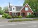 Charming brick home featuring an upstairs deck, a cozy front porch, and lovely garden landscaping at 1102 Lane St, Kannapolis, NC 28083