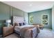 Bedroom features a tufted headboard, accent wall, and natural light from two windows at 11021 Warfield Ave # 03, Huntersville, NC 28078