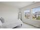 Well-lit bedroom featuring two windows, a cozy bed, and a full-length mirror at 13323 Savaine St, Charlotte, NC 28278