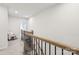Bright upstairs hallway featuring wood and wrought iron railing and neutral carpeting at 13323 Savaine St, Charlotte, NC 28278