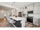 Bright kitchen boasts stainless appliances, white cabinets, dark island, and pendant lighting at 13323 Savaine St, Charlotte, NC 28278