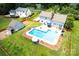 Aerial view of the backyard pool, patio, fence, and home at 13733 Castleford Dr, Mint Hill, NC 28227