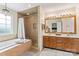 Luxurious bathroom featuring a soaking tub, tiled shower, and double vanity at 13733 Castleford Dr, Mint Hill, NC 28227
