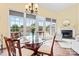 Elegant dining area with a glass table, chandelier, and backyard pool view at 13733 Castleford Dr, Mint Hill, NC 28227