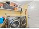Functional laundry room with washer, dryer, and shelving for storage at 13733 Castleford Dr, Mint Hill, NC 28227