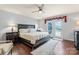 Inviting primary bedroom with pool access, dark wood floors, and a ceiling fan at 13733 Castleford Dr, Mint Hill, NC 28227