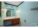 Bathroom with a large mirror, vanity, and built-in shelves with decorative trim on light green walls at 1553 Home Trl # 51, Lincolnton, NC 28092