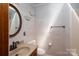 Bathroom with tile walls, round mirror, and modern fixtures, creating a clean and functional space at 1553 Home Trl # 51, Lincolnton, NC 28092