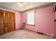 Pink bedroom featuring a ceiling fan, window, closet, carpeting, and decorative trim around the walls at 1553 Home Trl # 51, Lincolnton, NC 28092