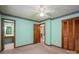 Carpeted bedroom with a ceiling fan, light green walls, decorative trim, and multiple closet doors at 1553 Home Trl # 51, Lincolnton, NC 28092