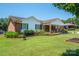 Landscaped front yard of a charming brick home featuring lush green lawn and well-maintained flower beds at 1553 Home Trl # 51, Lincolnton, NC 28092
