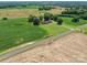 Aerial view of the property featuring fields, a pond, and a home with a long driveway at 1904 Old Peachland Rd, Marshville, NC 28103
