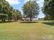 Spacious backyard with a playground set, trampoline, outbuilding, and mature trees at 1904 Old Peachland Rd, Marshville, NC 28103