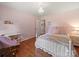 Bright bedroom featuring chandelier, hardwood floors, and white trim with a view into hall at 1904 Old Peachland Rd, Marshville, NC 28103