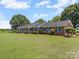 Charming brick home with a lush green lawn, blue shutters and mature landscaping at 1904 Old Peachland Rd, Marshville, NC 28103