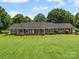 Charming brick home with a lush green lawn, blue shutters and mature landscaping at 1904 Old Peachland Rd, Marshville, NC 28103