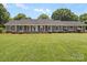 Charming brick home featuring blue shutters, white columns, and a well-manicured lawn at 1904 Old Peachland Rd, Marshville, NC 28103