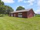 Side view of the large outbuilding with dual garage doors and a grassy field at 1904 Old Peachland Rd, Marshville, NC 28103