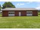 Large outbuilding with dual garage doors and a red metal roof, set in a grassy field at 1904 Old Peachland Rd, Marshville, NC 28103
