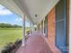 Long, covered porch with brick flooring and white columns, offering serene outdoor space at 1904 Old Peachland Rd, Marshville, NC 28103