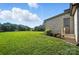Well-maintained backyard with a grassy lawn leading to a brick home with a side entrance and landscape at 200 Squash Harvest Ct, Matthews, NC 28104