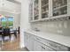 Bar area with glass cabinets, wine glass storage, and view of dining area at 200 Squash Harvest Ct, Matthews, NC 28104