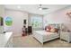 Cozy bedroom featuring a white bed frame, round window, ceiling fan and ample natural light at 200 Squash Harvest Ct, Matthews, NC 28104