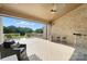 Spacious covered brick deck with ceiling fan, sleek furniture, and an inviting outdoor living space at 200 Squash Harvest Ct, Matthews, NC 28104