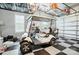 Clean garage featuring checkered flooring, overhead storage racks, and a modern golf cart at 200 Squash Harvest Ct, Matthews, NC 28104