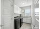 Modern laundry room featuring white cabinets, countertop space, stainless steel appliances and window at 200 Squash Harvest Ct, Matthews, NC 28104