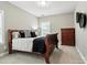 Cozy bedroom with traditional cherry furniture, a bed with patterned pillows, and a bright window at 2377 Maple Grove Nw Ln, Concord, NC 28027