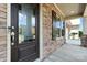 Close-up of front door featuring stone detail, glass accents, a secure lock, and sidelight windows at 2377 Maple Grove Nw Ln, Concord, NC 28027