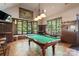 Spacious game room with pool table, chandelier lighting, and large windows with wooded views at 2377 Maple Grove Nw Ln, Concord, NC 28027