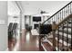 Open living space with hardwood floors, a modern staircase, and a view of the living room with a TV and fireplace at 2377 Maple Grove Nw Ln, Concord, NC 28027