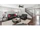 Stylish living room with a textured wall, dark furniture, and a staircase to the upper level at 2377 Maple Grove Nw Ln, Concord, NC 28027