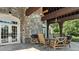Covered outdoor patio boasts stone columns, ceiling fans, and comfortable seating area at 2377 Maple Grove Nw Ln, Concord, NC 28027