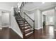 Elegant hardwood staircase featuring a wrought iron railing, leading to upper levels of the home with hardwood floors at 2377 Maple Grove Nw Ln, Concord, NC 28027