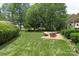 Picturesque backyard with lush green grass, seating, and mature trees at 3003 Wedge Ct, Matthews, NC 28104