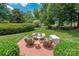 Inviting backyard brick patio with wicker seating and well-manicured landscaping at 3003 Wedge Ct, Matthews, NC 28104