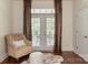 Comfortable sitting area in bedroom with a tufted chair and ottoman, and french doors to the backyard at 3003 Wedge Ct, Matthews, NC 28104