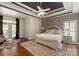 Elegant primary bedroom boasts a tray ceiling, stylish wallpaper, and french doors to the backyard at 3003 Wedge Ct, Matthews, NC 28104