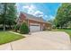 Side exterior showcasing a brick home with a spacious driveway and manicured landscaping at 3003 Wedge Ct, Matthews, NC 28104