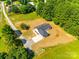 An aerial view of a quaint house with a concrete driveway, surrounded by a well-maintained lawn and mature trees at 3248 Ferguson Long Rd, York, SC 29745