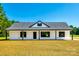 Beautiful white home with black trim, a well-manicured lawn, and a classic gable roof at 3248 Ferguson Long Rd, York, SC 29745