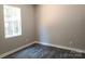This bedroom has a window providing natural light, gray walls and wood-look flooring at 372 Lippard Farm Rd, Statesville, NC 28625